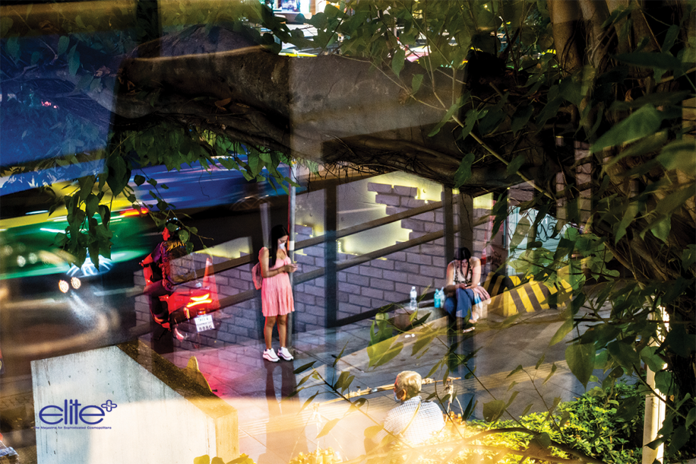 Sukhumvit street scene through a cafe window; midnight food sellers on Soi 13.