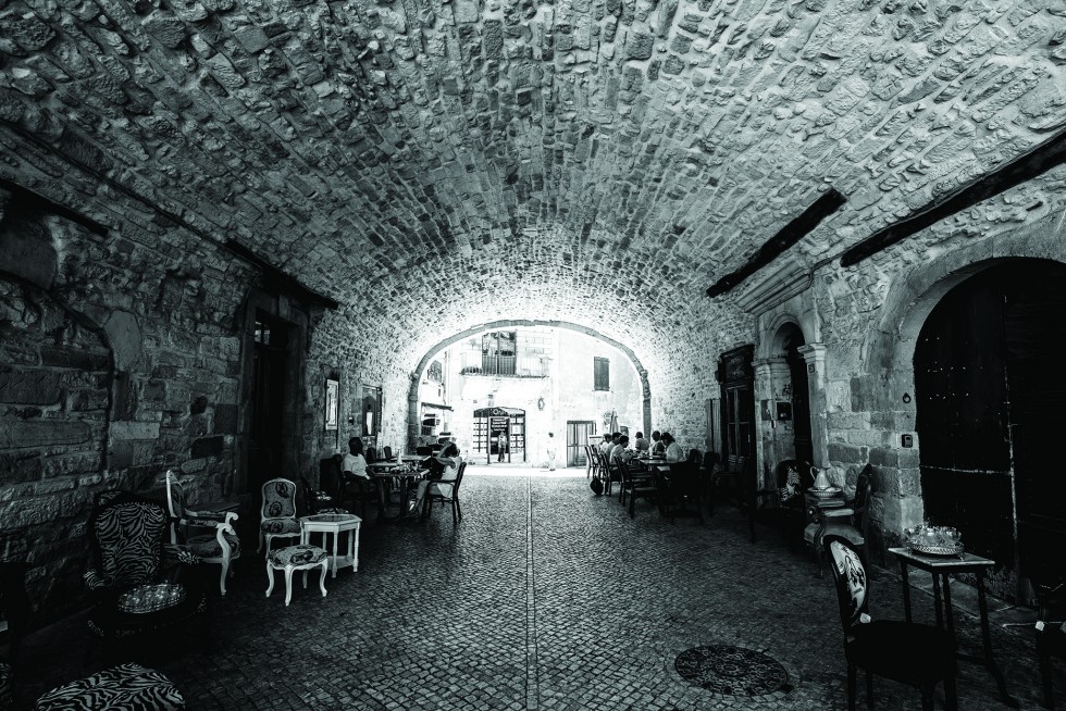 Many cafes shelter from the sun under city fortifications.